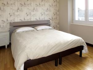 Plounévez-LochristにあるHoliday Home Ty Thérèse - PLR205 by Interhomeのベッドルーム(白いシーツを使用した大型ベッド1台付)