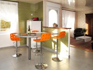 Plounévez-LochristにあるHoliday Home Ty Thérèse - PLR205 by Interhomeのキッチン(テーブル、オレンジチェア付)