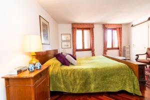 a bedroom with a bed with a green blanket at Ca del Duca Canal Grande in Venice