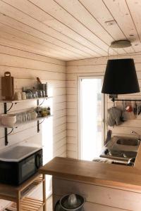 LanildutにあるHoliday Home Maison d'en bas - LDT103 by Interhomeの木製の壁のキッチン(電子レンジ付きのテーブル付)