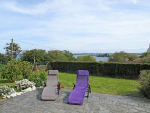 2 sillas de césped moradas en un patio con vistas al agua en Holiday Home La Mouette - P, en Kertissiec