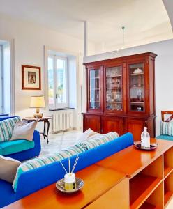 Villa Falconieri Sorrento Suite في سانتّانييلّو: غرفة معيشة مع أريكة زرقاء وطاولة