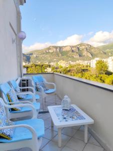 聖安吉洛的住宿－Villa Falconieri Sorrento Suite，阳台配有蓝色椅子和桌子,享有美景。