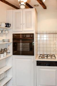een keuken met witte kasten en een fornuis met oven bij Holiday Home Le Coteau Fleury by Interhome in Luynes