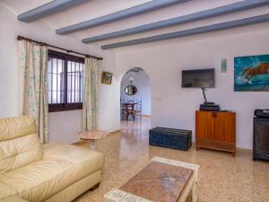 a living room with a couch and a tv at Holiday Home Forest by Interhome in Benitachell +21 photos