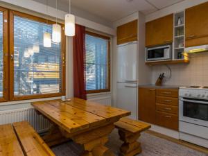 eine Küche mit Holztisch und Kühlschrank in der Unterkunft Holiday Home Karhunvartijan pirtti b2 by Interhome in Ruka