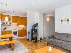 ein Wohnzimmer mit Couch und Küche in der Unterkunft Holiday Home Karhunvartijan pirtti b2 by Interhome in Ruka