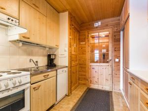 a kitchen with white appliances and wooden cabinets at Holiday Home Mestarikämpät b10 by Interhome in Ruka