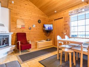 a dining room with a fireplace and a tv at Holiday Home Mestarikämpät b10 by Interhome in Ruka