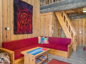 ein Wohnzimmer mit einem roten Sofa und einem Tisch in der Unterkunft Holiday Home Rinnekieppi 1 by Interhome in Ruka