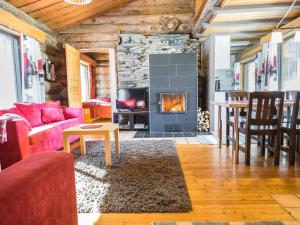 ein Wohnzimmer mit Couch und Kamin in der Unterkunft Holiday Home Mustalampi 2 kurkiaura by Interhome in Ruka