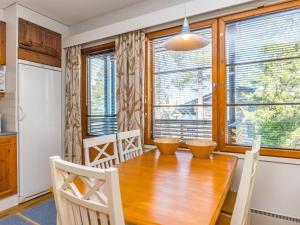 a kitchen and dining room with a wooden table and chairs at Holiday Home Karhunvartijan linna c18 by Interhome in Ruka