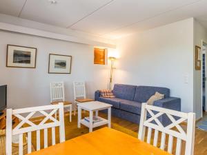 a living room with a blue couch and a table at Holiday Home Karhunvartijan linna c18 by Interhome in Ruka