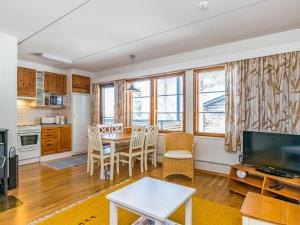 a kitchen and living room with a table and chairs at Holiday Home Karhunvartijan linna c18 by Interhome in Ruka