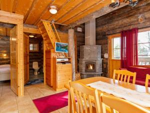 a dining room with a table and a fireplace in a log cabin at Holiday Home Saaruantupa by Interhome in Ruka