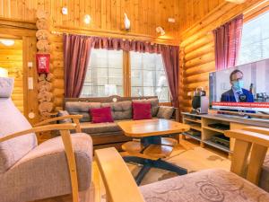a living room with a couch and a tv at Holiday Home Keisarintupa by Interhome in Ruka