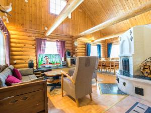 a living room with a fireplace in a log cabin at Holiday Home Keisarintupa by Interhome in Ruka
