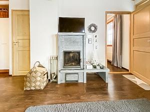 a living room with a fireplace and a television at Holiday Home Länsirinne c 12 by Interhome in Ruka +8 photos