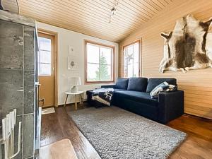 een woonkamer met een blauwe bank en een tapijt bij Holiday Home Länsirinne c 12 by Interhome in Ruka