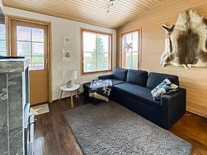 un soggiorno con divano blu e camino di Holiday Home Länsirinne c 12 by Interhome a Ruka