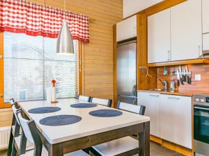 eine Küche mit einem Tisch und Stühlen in einer Küche in der Unterkunft Holiday Home Länsirinne e 20 by Interhome in Ruka