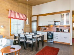 eine Küche mit Tisch und Stühlen in einem Zimmer in der Unterkunft Holiday Home Länsirinne e 20 by Interhome in Ruka