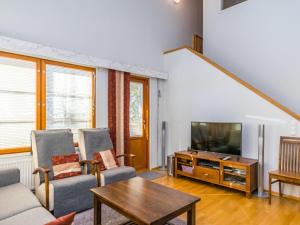 ein Wohnzimmer mit einem Sofa und einem TV in der Unterkunft Holiday Home Karhunvartijan pirtti c4 by Interhome in Ruka