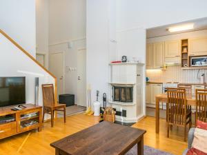 a living room with a dining table and a kitchen at Holiday Home Karhunvartijan pirtti c4 by Interhome in Ruka