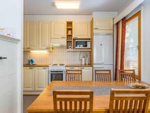 a kitchen with a large wooden table and chairs at Holiday Home Karhunvartijan pirtti c4 by Interhome in Ruka
