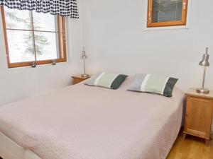a bedroom with a white bed with two pillows on it at Holiday Home Karhunvartijan linna a2 by Interhome in Ruka