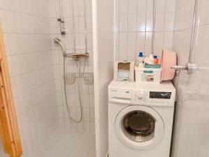 a bathroom with a washing machine and a shower at Holiday Home Karhunvartijan linna a2 by Interhome in Ruka +5 photos