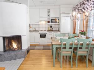 a kitchen with a table and chairs and a fireplace at Holiday Home Karhunvartijan linna a2 by Interhome in Ruka