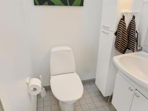 a white bathroom with a toilet and a sink at Holiday Home Karhunvartijan linna a2 by Interhome in Ruka