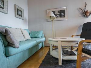 a living room with a blue couch and a table at Holiday Home Palokärki by Interhome in Ruka