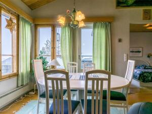 a dining room with a table and chairs and windows at Holiday Home Palokärki by Interhome in Ruka