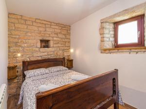 a bedroom with a bed and a stone wall at Holiday Home Vera by Interhome in Sveti Ivan