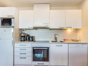 una cocina blanca con armarios blancos y fregadero en Holiday Home Ruka ski chalets 64- 1503 by Interhome en Ruka