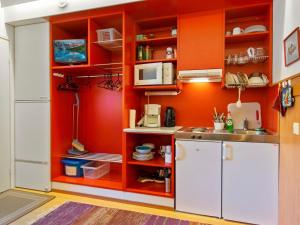- une cuisine avec des murs orange et un réfrigérateur blanc dans l'établissement Holiday Home Vuosselin helmi c25 by Interhome, à Ruka