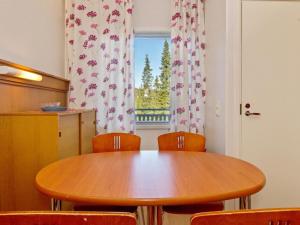 un tavolo in legno con sedie in una stanza con finestra di Holiday Home Vuosselin helmi c25 by Interhome a Ruka
