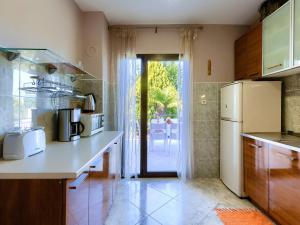 a kitchen with a refrigerator and a door to a patio at Holiday Home Dora by Interhome in Modrušani