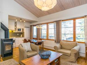 a living room with a fireplace and a table at Holiday Home Karhunvartijan linna c22 by Interhome in Ruka
