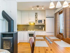 a kitchen and dining room with a table and a stove at Holiday Home Karhunvartijan linna c22 by Interhome in Ruka