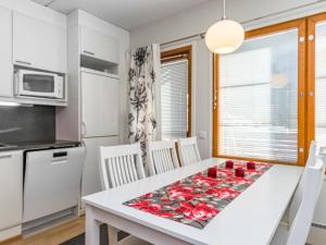 eine Küche und ein Esszimmer mit einem Tisch mit roten Rosen darauf in der Unterkunft Holiday Home Karhunvartijan kota b1 by Interhome in Ruka + 9 Fotos