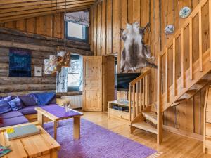 a living room with a couch and stairs in a cabin at Holiday Home Saaruanaho h1 by Interhome in Ruka