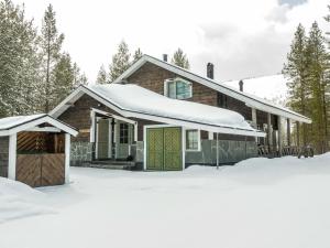 a house with a garage in the snow at Holiday Home Villa pirkkalinna by Interhome in Levi