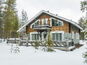 ein Blockhaus im Schnee im Wald in der Unterkunft Holiday Home Villa pirkkalinna by Interhome in Levi