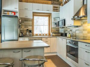 a kitchen with white cabinets and stainless steel appliances at Holiday Home Kotkanpesä by Interhome in Levi