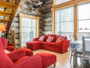 a living room with red chairs and a red couch at Holiday Home Kotkanpesä by Interhome in Levi