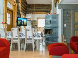 a dining room with a table and a stove at Holiday Home Kotkanpesä by Interhome in Levi