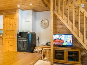 ein Wohnzimmer mit Holztreppe und TV in der Unterkunft Holiday Home Hirvas levi 4 by Interhome in Levi + 8 Fotos